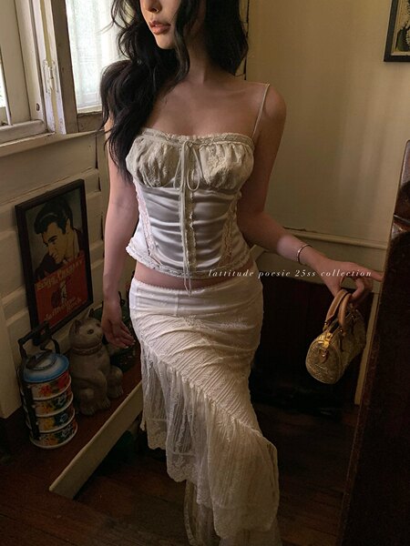 Model wearing a cream lace corset top and matching skirt set