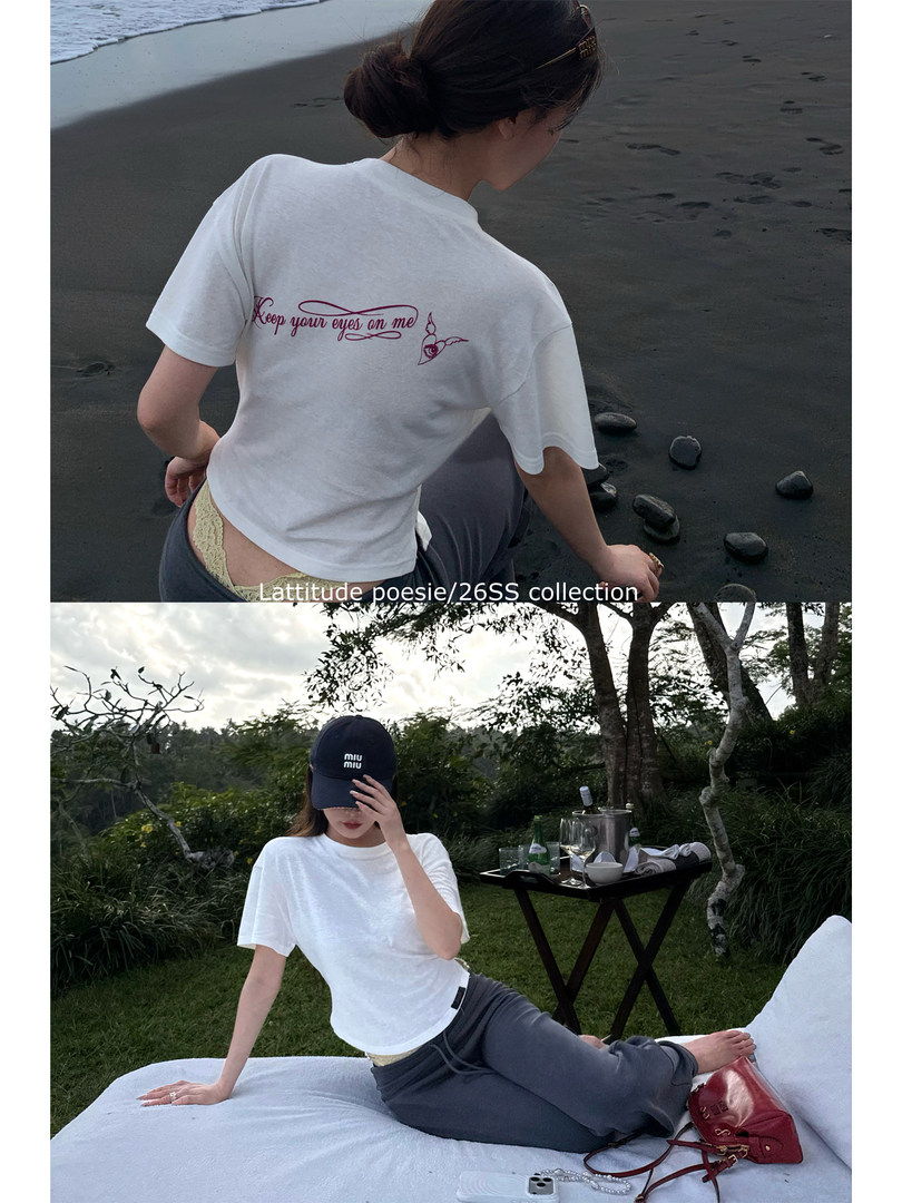 White graphic T-shirt worn by a model in an outdoor beach and picnic setting