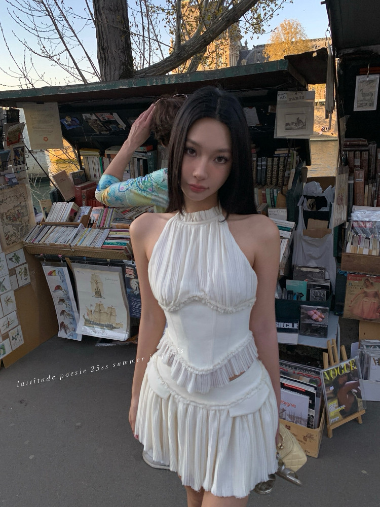 White pleated halter dress worn by a model outdoors
