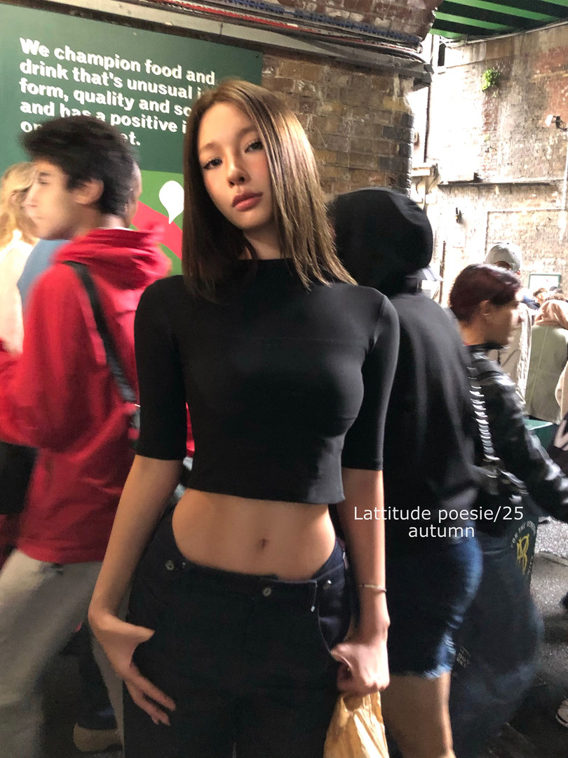 Model wearing a black fitted crop top and black pants