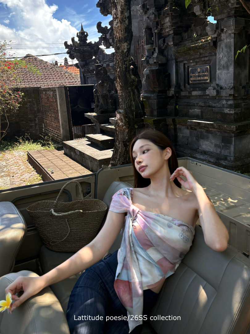 Woman wearing a pastel wrap top/scarf in an outdoor travel setting
