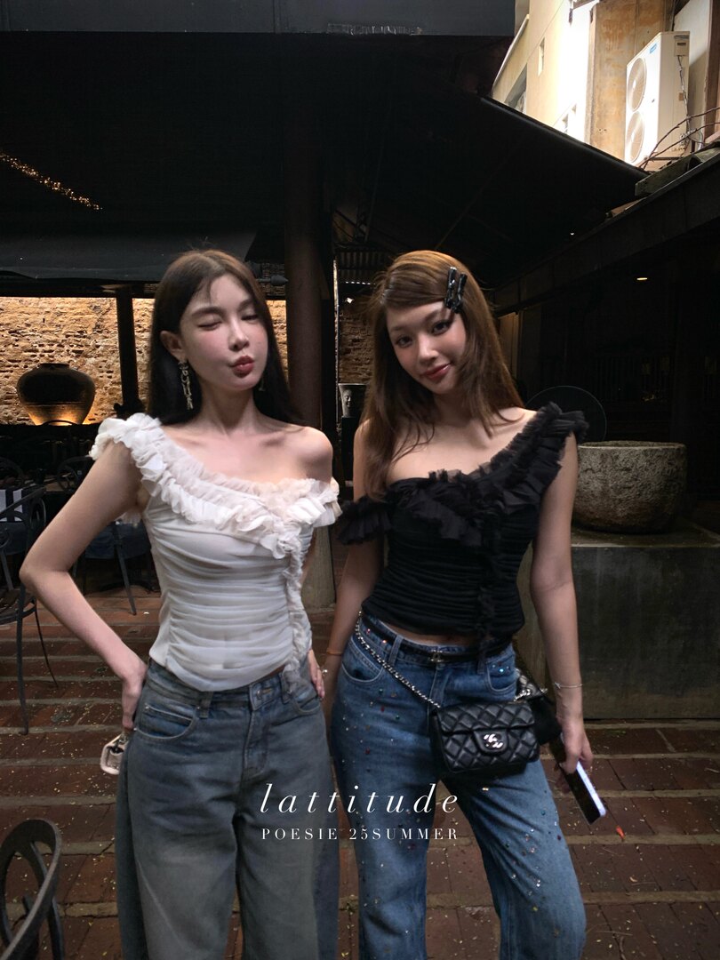 Two women wearing ruffled off-shoulder tops with jeans in a summer fashion promo