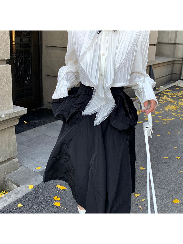White blouse paired with a black skirt worn outdoors
