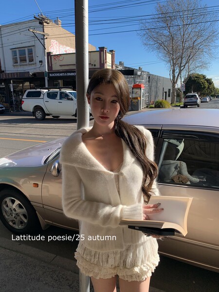 Model wearing an ivory knit cardigan and ruffled lace mini skirt outdoors
