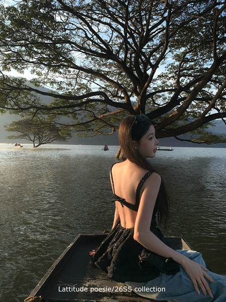Woman wearing a black backless dress on a boat by the water