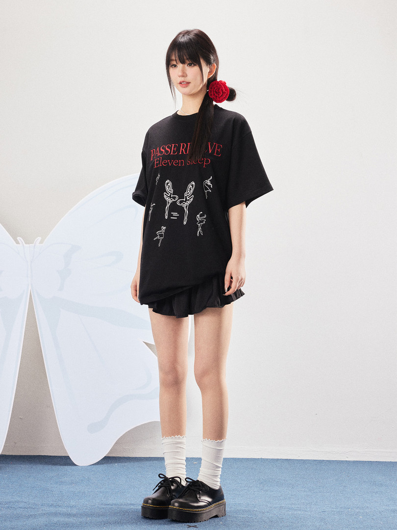 Model wearing a black oversized graphic T-shirt with platform shoes