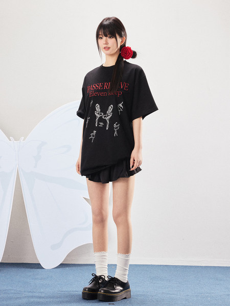 Model wearing a black oversized graphic T-shirt with platform shoes