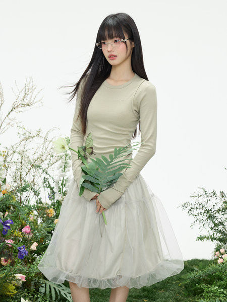 Light beige long-sleeve dress with a sheer tulle skirt worn by a model