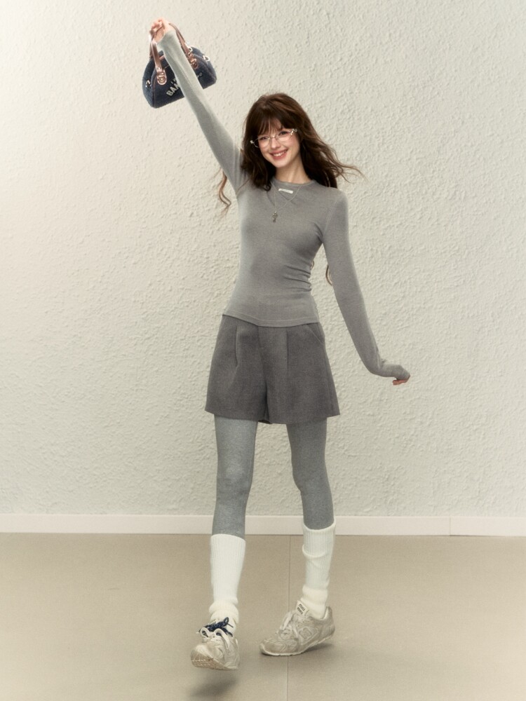 Woman wearing a gray fitted long-sleeve top with matching shorts and leggings