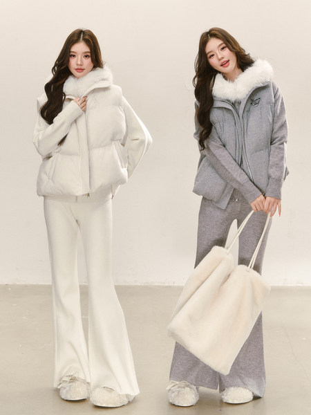 Two women wearing cozy winter outfits with fur-trim hooded jackets and matching pants