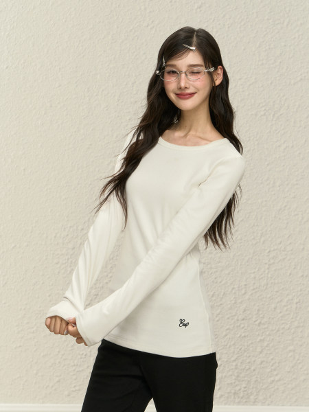 Model wearing a white long-sleeve top with black pants