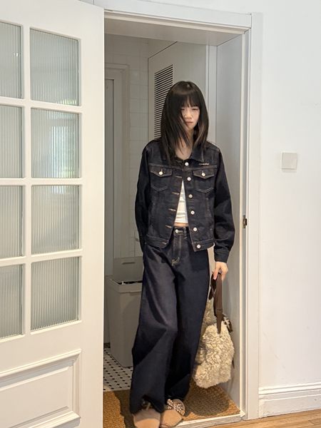 Model wearing a dark denim jacket and wide-leg jeans