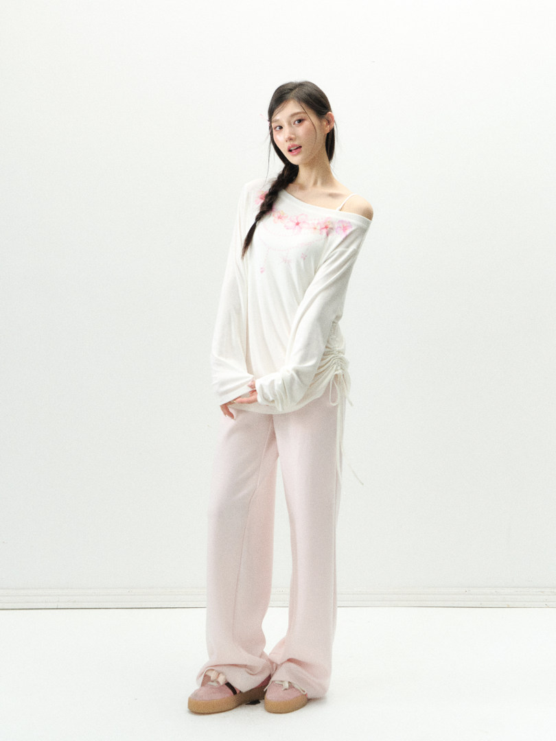 Model wearing a white off-shoulder top with pink lounge pants