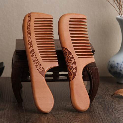 A wooden comb with a thick double-faced peached wood comb ag