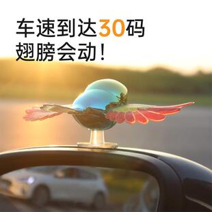A car with a cute ornament and a little birds helmet with a
