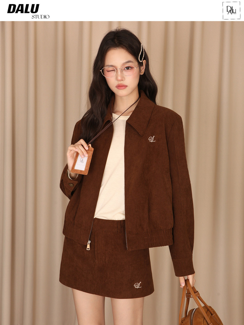 Model wearing a brown jacket and matching skirt set with a cream top