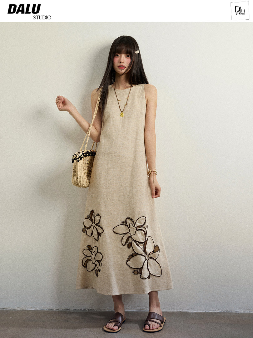 Model wearing a sleeveless beige floral-embroidered midi dress