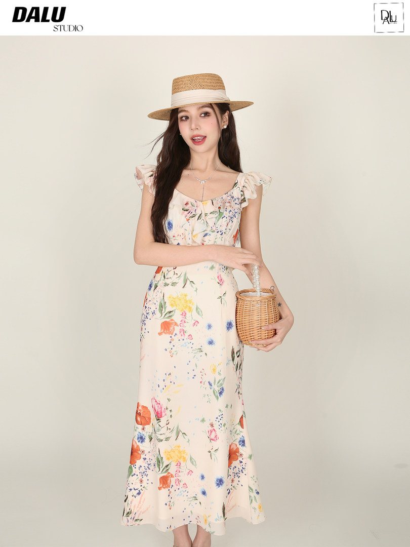 Floral sleeveless midi dress worn by a model with a straw hat and wicker bag