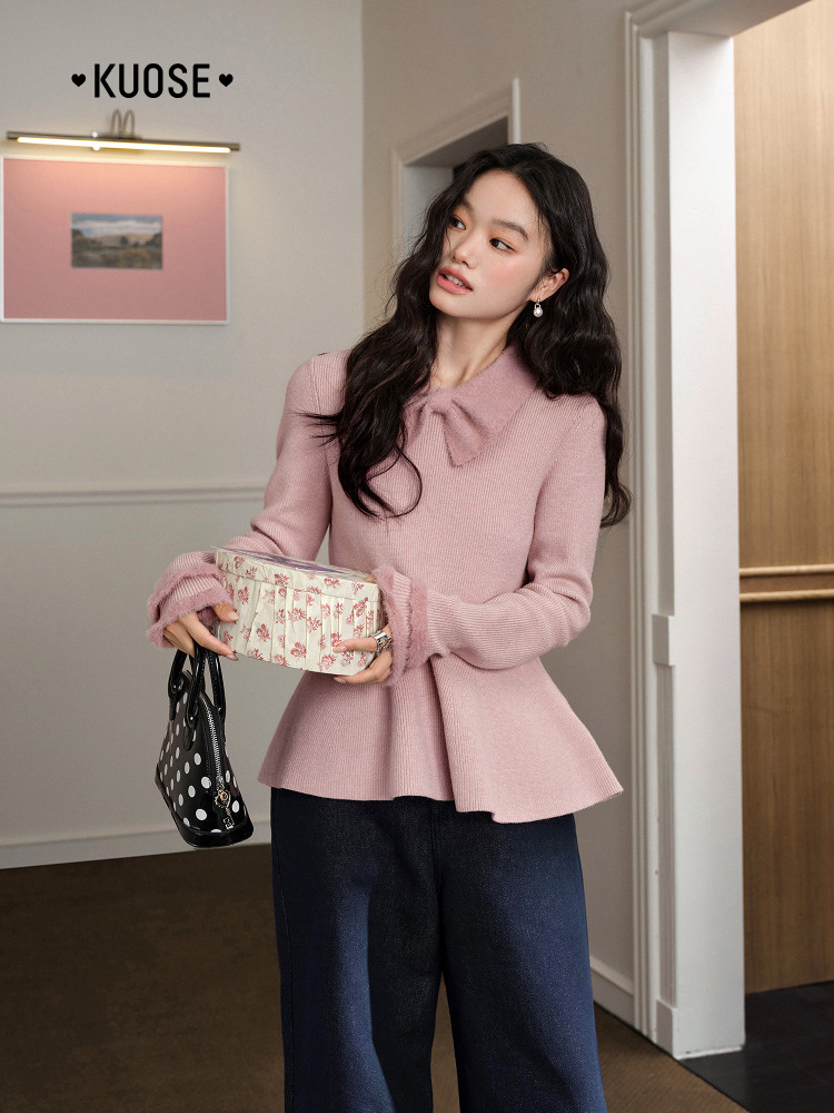 Model wearing a pink knit peplum sweater top with dark pants