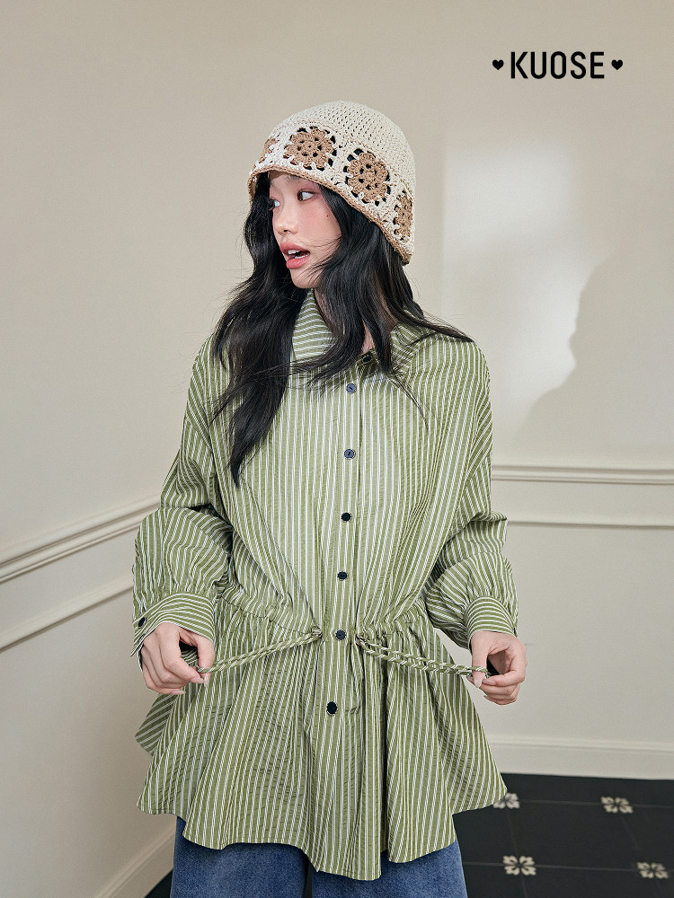 Model wearing a green striped button-up shirt with a crochet bucket hat