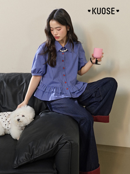 Model wearing a blue checkered short-sleeve blouse with dark jeans