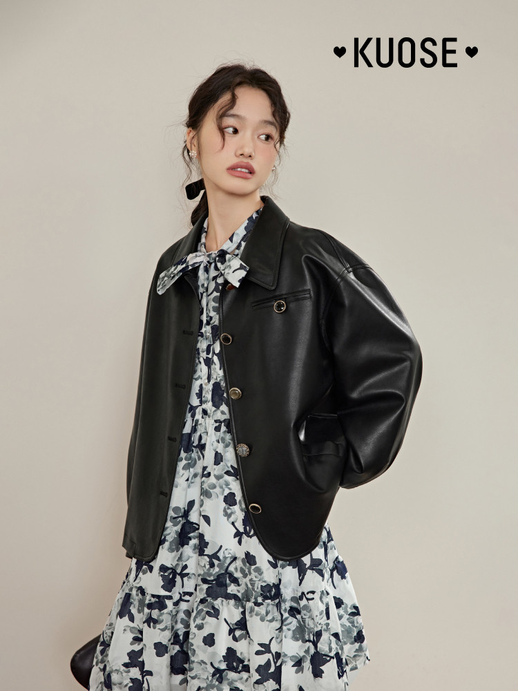 Model wearing a black leather jacket over a floral dress