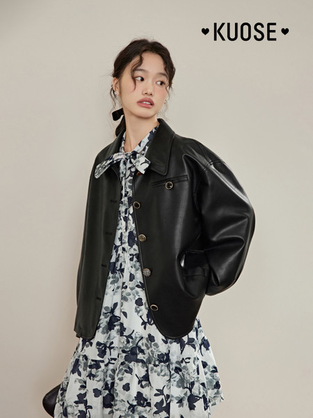 Model wearing a black leather jacket over a floral dress