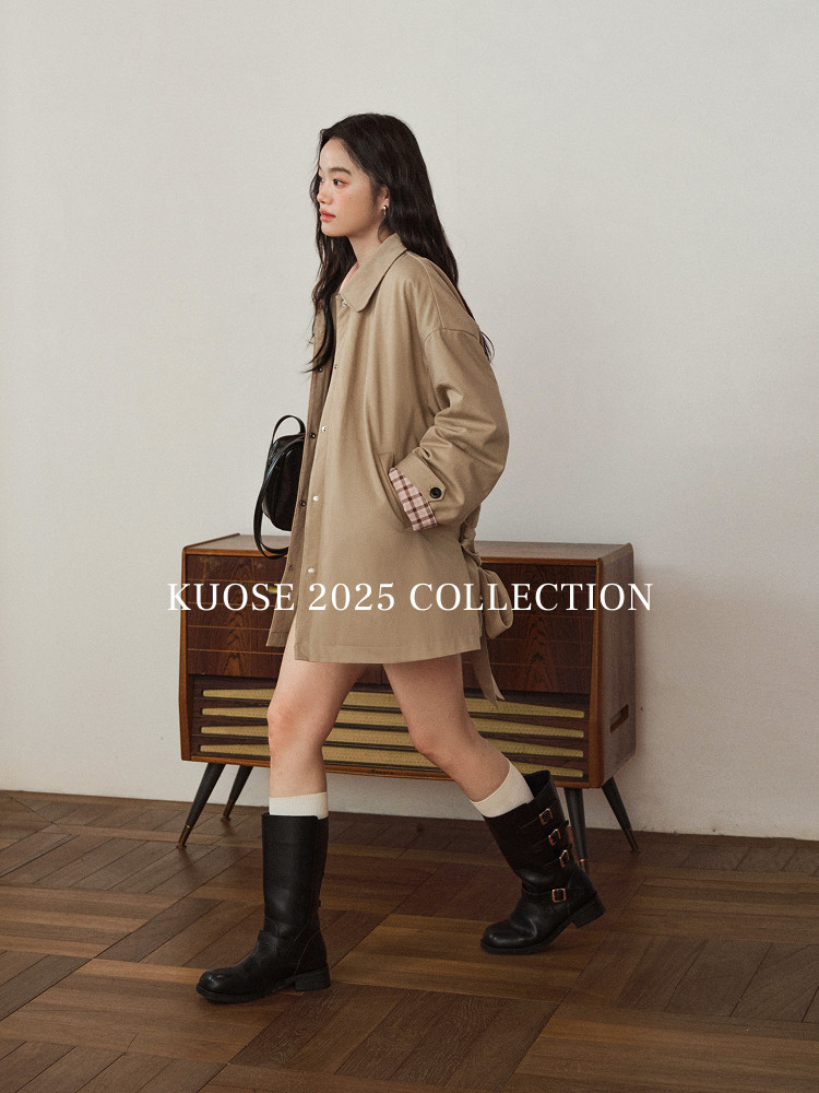 Model wearing a beige oversized jacket with black knee-high boots