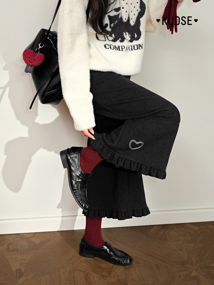 Model wearing a black ruffled skirt with a white fuzzy sweater and black loafers