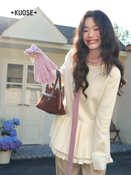 Model wearing a cream pastel outfit with a small brown handbag and pink gloves