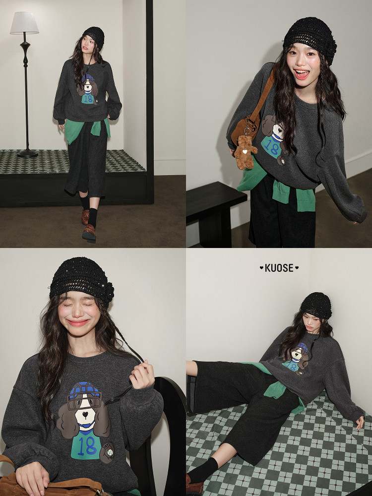 Model wearing a dark oversized graphic sweatshirt with black pants and a knit hat