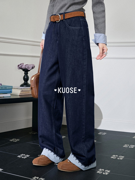 Wide-leg dark denim jeans worn with a belt and loafers