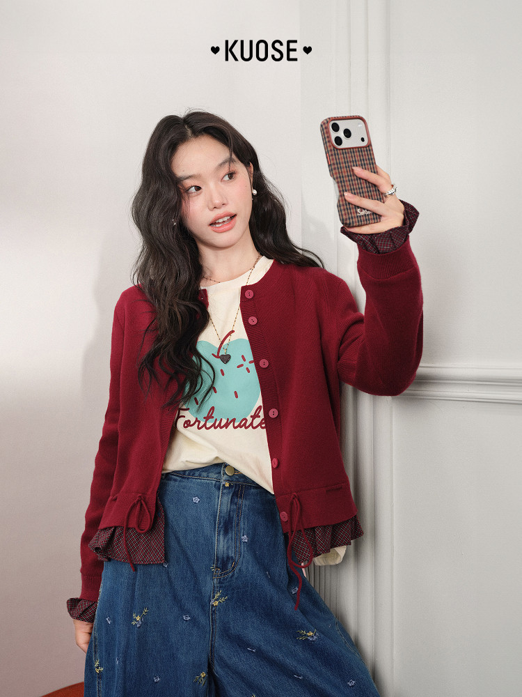 Model wearing a burgundy cardigan over a graphic tee with a denim skirt
