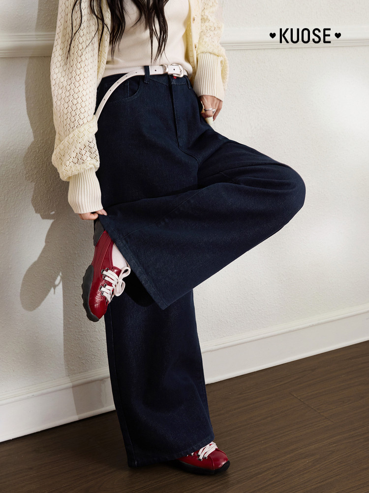 Model wearing dark wide-leg pants with a cream sweater and red shoes