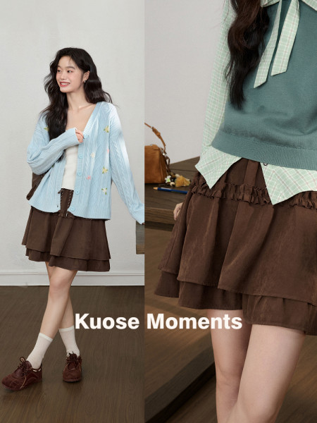 Fashion model wearing a light blue cardigan and brown layered skirt outfit