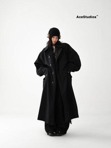 Model wearing a black oversized long coat with a minimalist fashion look