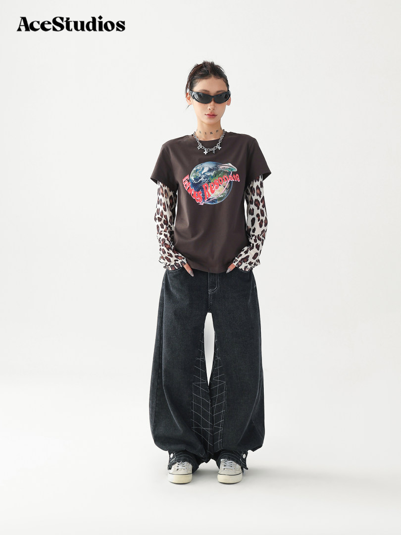 Model wearing a graphic streetwear outfit with oversized black pants and layered long sleeves