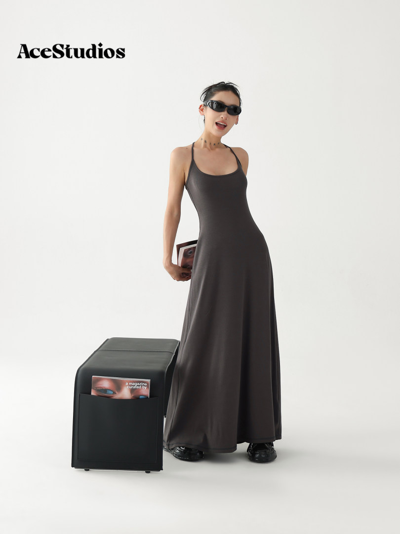 Model wearing a dark gray sleeveless maxi dress with a halter-style neckline