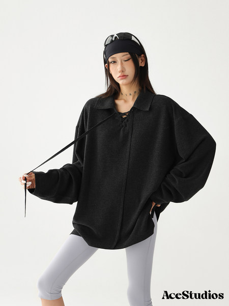 Model wearing an oversized black pullover top with white leggings