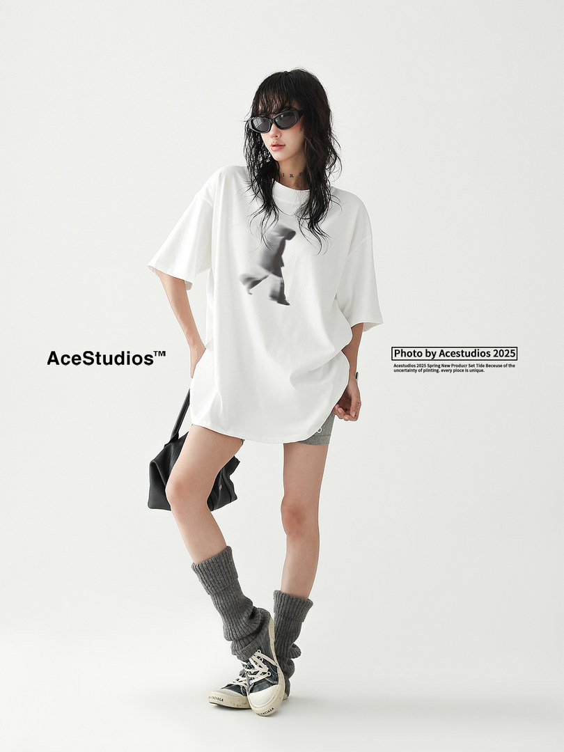 Model wearing an oversized white graphic T-shirt with black accessories