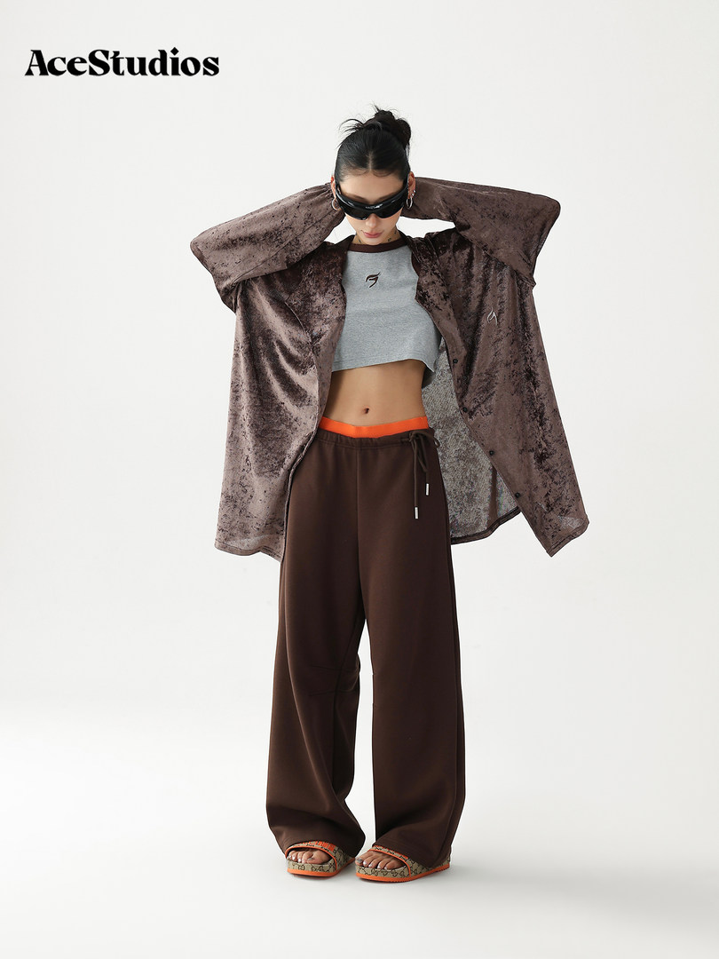 Model wearing a brown velvet oversized jacket with crop top and wide-leg pants