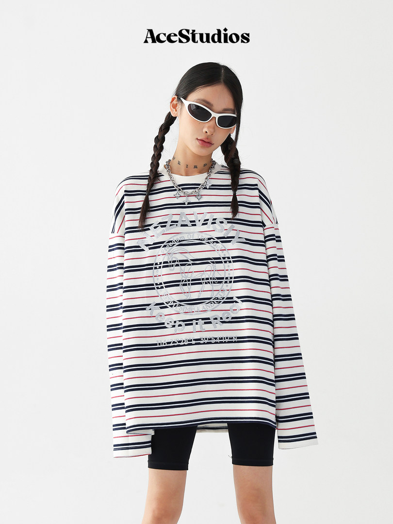Model wearing an oversized striped graphic long-sleeve top with sunglasses