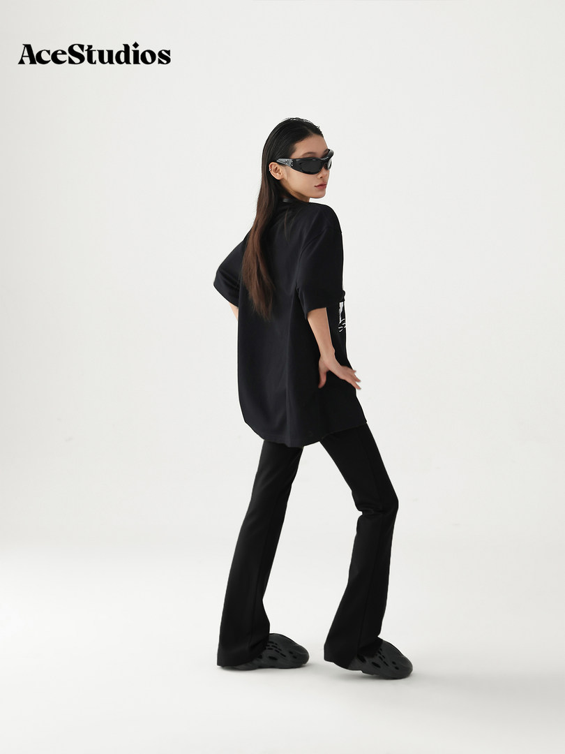 Model wearing a black oversized outfit with sunglasses and black shoes