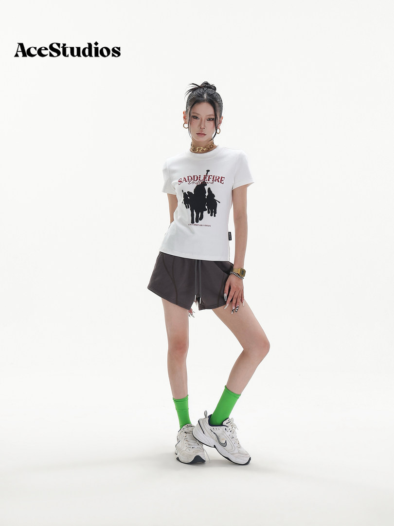 Model wearing a graphic white T-shirt, dark shorts, and sneakers