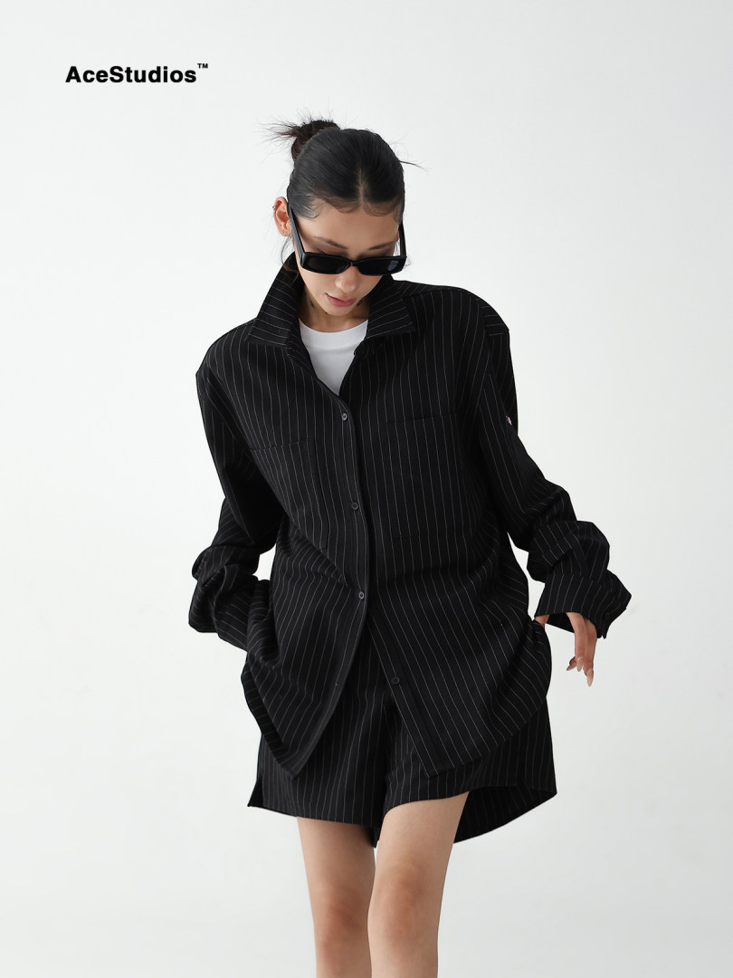 Model wearing a black pinstripe oversized shirt and matching shorts set