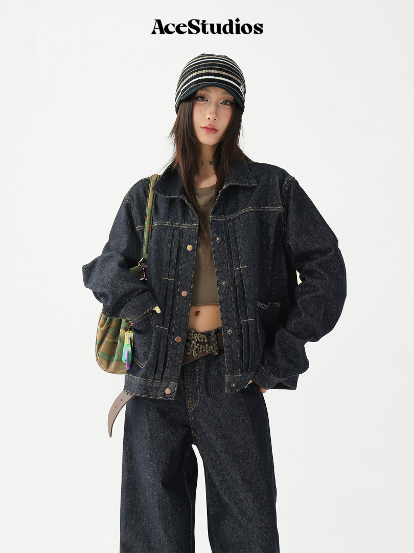 Model wearing a dark denim jacket and wide-leg jeans with a striped beanie
