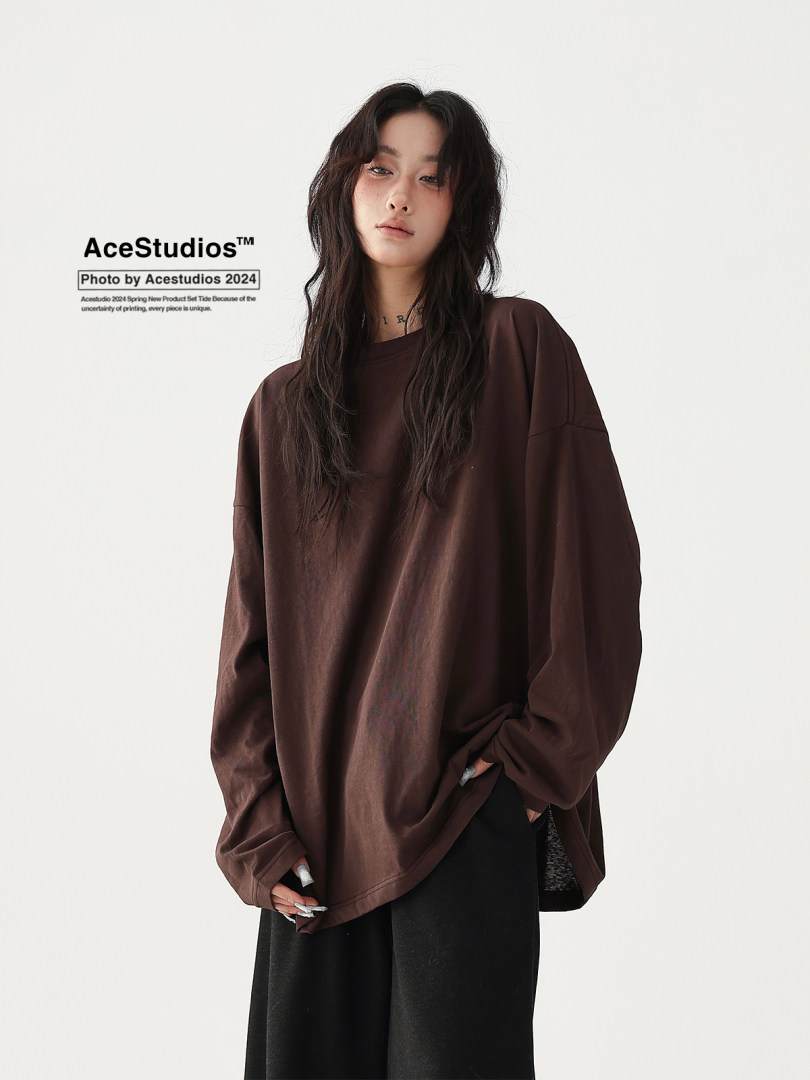 Model wearing an oversized brown long-sleeve top on a white background