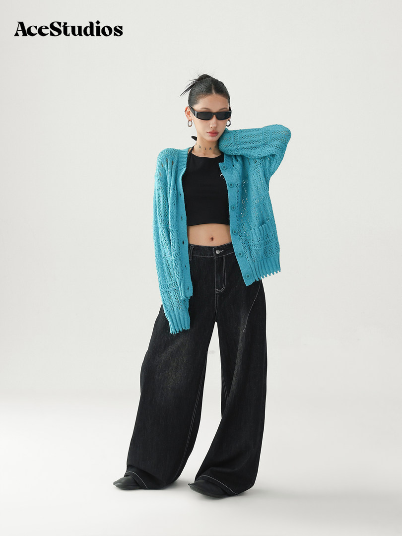 Model wearing a turquoise knit cardigan with black crop top and wide-leg black jeans