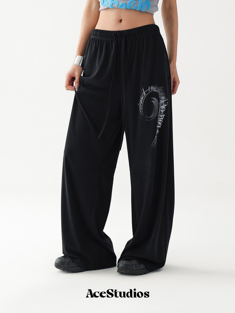 Black wide-leg pants worn by a model with graphic print detail