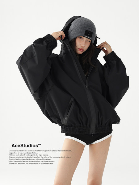Black oversized hooded jacket worn by a model with a beanie
